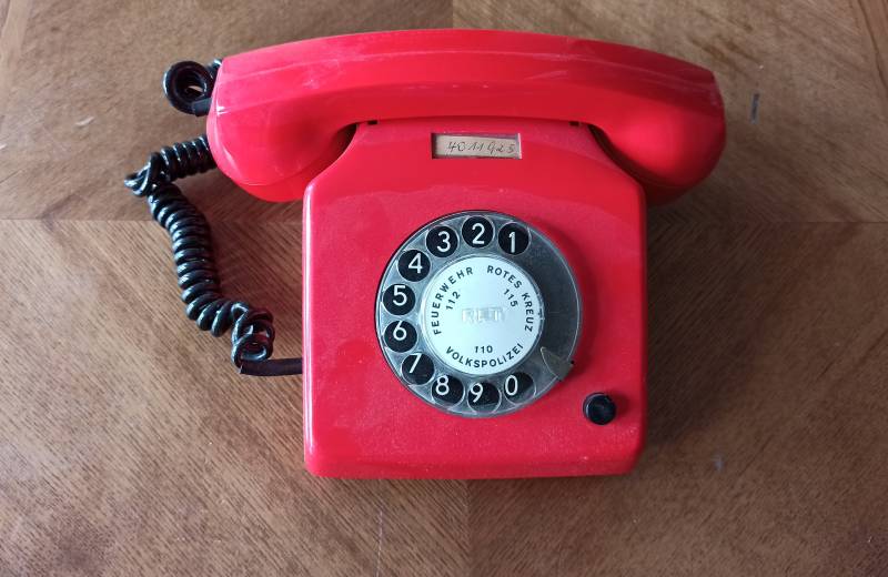 Rotes altes Telefon auf einem Tisch stehend