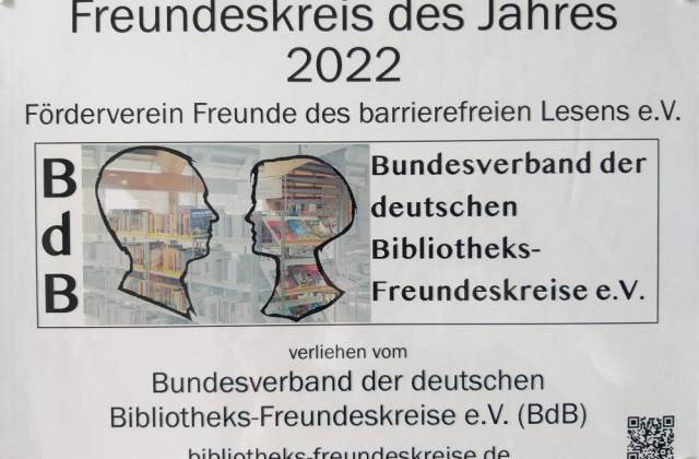 Ansicht der Plakette des Bundesverbands der Bibliotheksfreundeskreise für den Freundeskreis des Jahres 2022 "Freunde des barrierefreien Lesens e.V." Schwarzschrift auf farblosem Kunststoff mit Logo des BdB