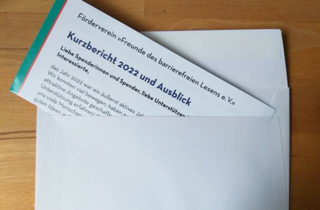 Auf einem Tisch liegt ein weißer Umschlag, aus dem der Jahresbericht herausschaut.