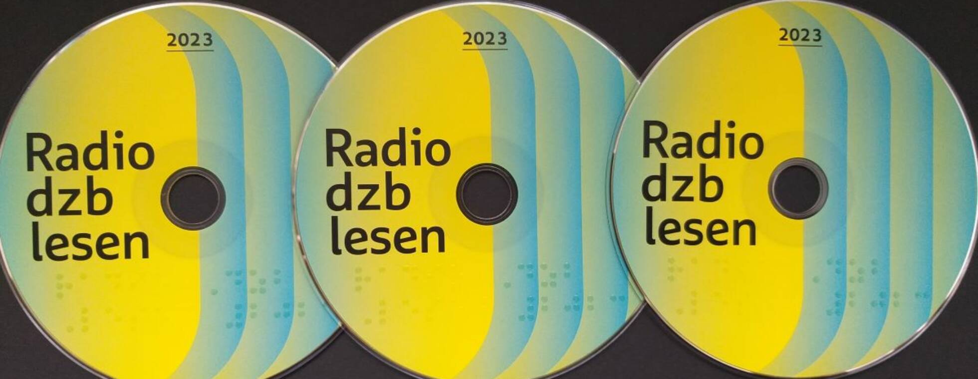 3 bunt gestaltete CDs der Radio dzb lesen 2023 auf schwarzem Hintergrund aufgereiht