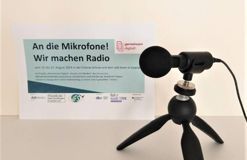 Ein Mikrofon steht vor dem Plakat zum Radioprojekt