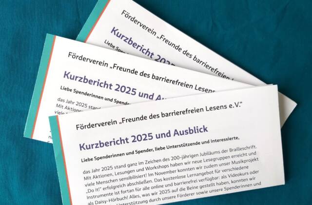 drei gefaltete Exemplare des Jahresberichts 2025 vor türkisblauem Hintergrund