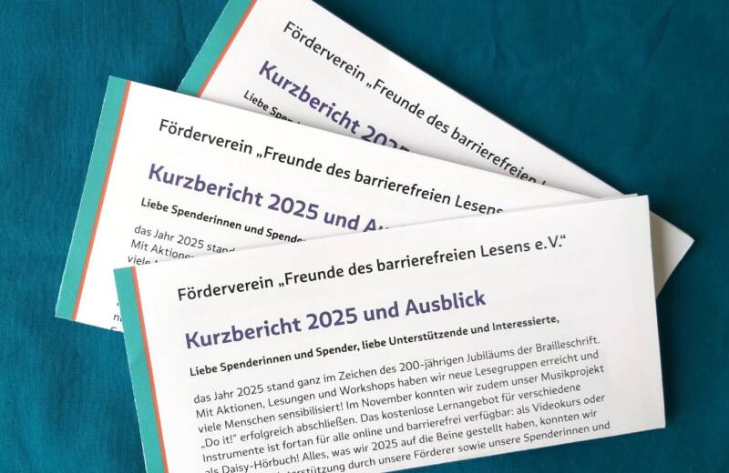 drei gefaltete Exemplare des Jahresberichts 2025 vor türkisblauem Hintergrund