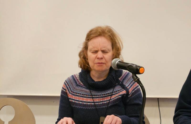 Vorstandsmitglied Anja Lehmann sitzt vor Mikrofon und Braillezeile an einem Tisch.